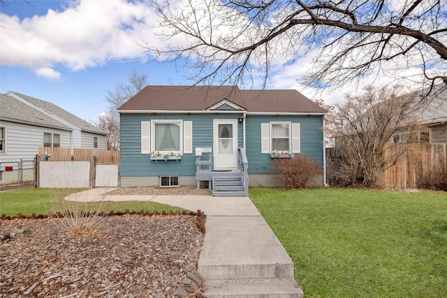 bungalow-style home with fence and a front lawn
