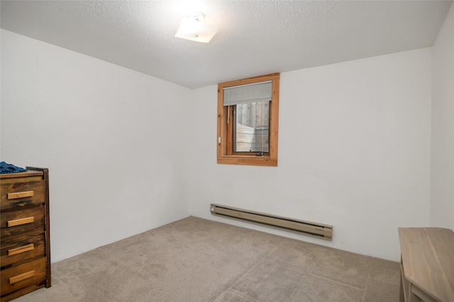 spare room with a baseboard radiator, carpet flooring, and a textured ceiling