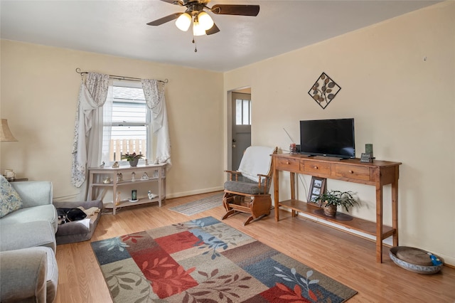 living room with baseboards, wood finished floors, and ceiling fan