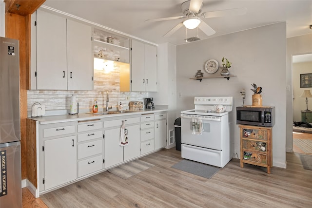kitchen featuring white electric range oven, decorative backsplash, stainless steel microwave, a sink, and light wood-style floors