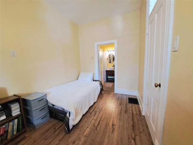 1026 11th Ave, Helena, MT 59601 - bedroom with wood-type flooring, baseboards, and connected bathroom