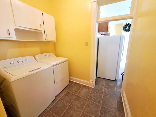 1026 11th Ave, Helena, MT 59601 - laundry area with cabinet space, washing machine and clothes dryer, baseboards, and dark tile patterned flooring