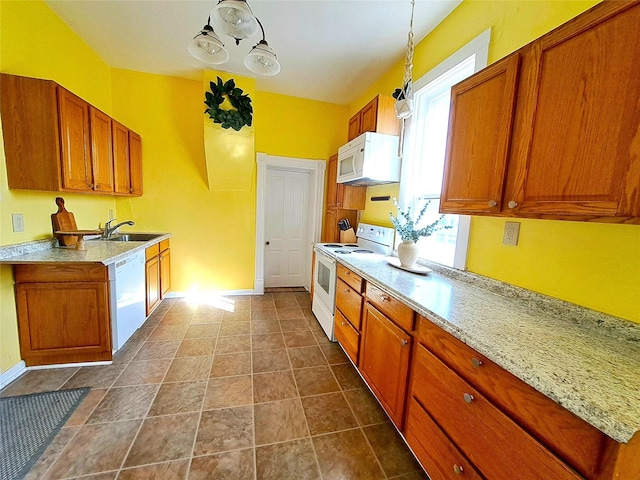 1026 11th Ave, Helena, MT 59601 - kitchen with white appliances, brown cabinetry, a sink, and baseboards