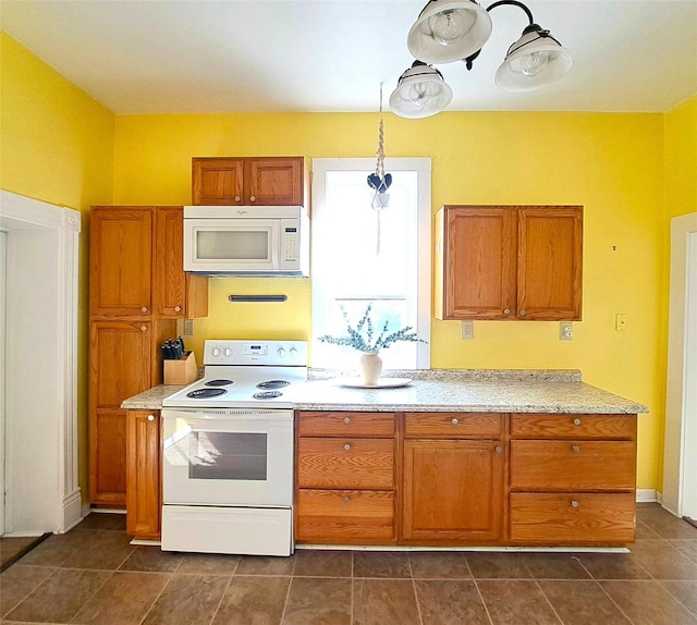 1026 11th Ave, Helena, MT 59601 - kitchen with white appliances, brown cabinetry, and light countertops
