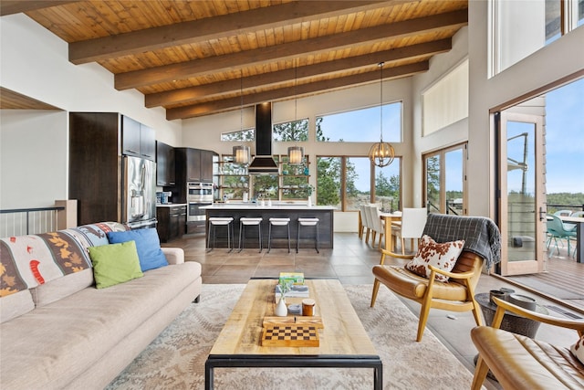 280 Cowgirl Cv, Eureka, MT 59917 - living room featuring wood ceiling, beam ceiling, a high ceiling, an inviting chandelier, and light tile patterned floors
