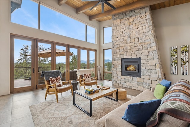 280 Cowgirl Cv, Eureka, MT 59917 - tiled living area with wood ceiling, a fireplace, a ceiling fan, and beam ceiling