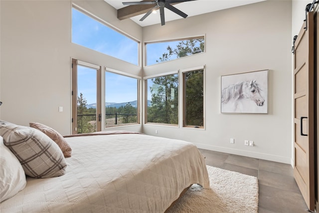 280 Cowgirl Cv, Eureka, MT 59917 - bedroom with baseboards, a barn door, ceiling fan, and a high ceiling
