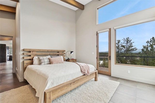 280 Cowgirl Cv, Eureka, MT 59917 - tiled bedroom with beam ceiling, a towering ceiling, baseboards, and access to outside