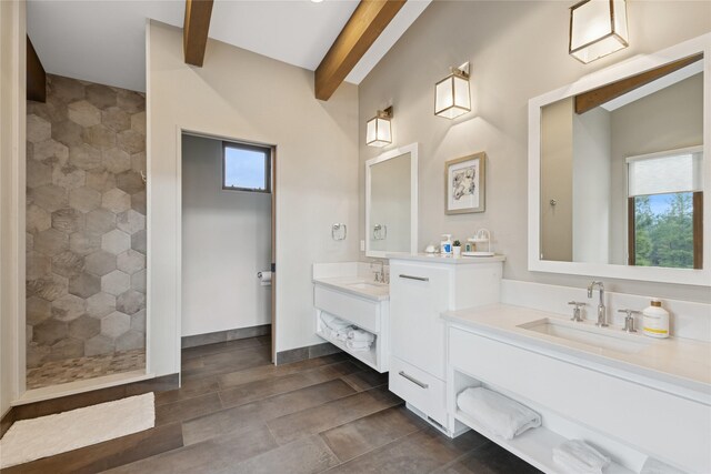 280 Cowgirl Cv, Eureka, MT 59917 - bathroom featuring two vanities, a sink, beam ceiling, and tiled shower