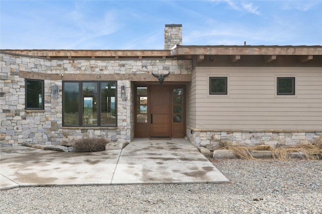 280 Cowgirl Cv, Eureka, MT 59917 - property entrance with a chimney and stone siding