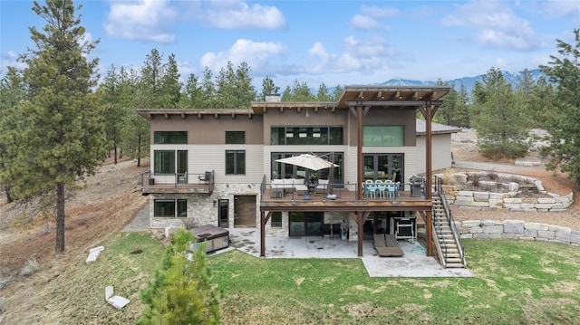 280 Cowgirl Cv, Eureka, MT 59917 - rear view of property featuring stone siding, a wooden deck, a patio, stairs, and a yard