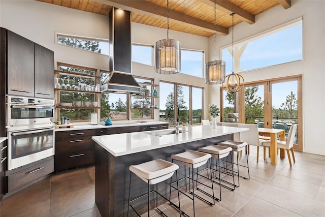 280 Cowgirl Cv, Eureka, MT 59917 - kitchen featuring stainless steel double oven, wooden ceiling, island exhaust hood, a sink, and a notable chandelier