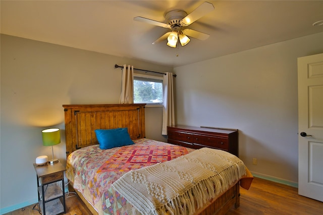 bedroom with baseboards, wood finished floors, and ceiling fan