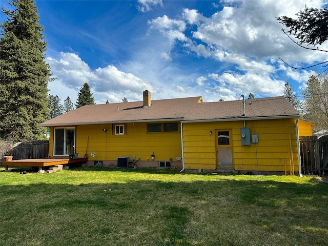 back of house featuring a chimney, fence, a deck, central AC, and a yard