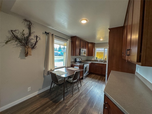 dining space featuring a wealth of natural light, baseboards, and dark wood finished floors
