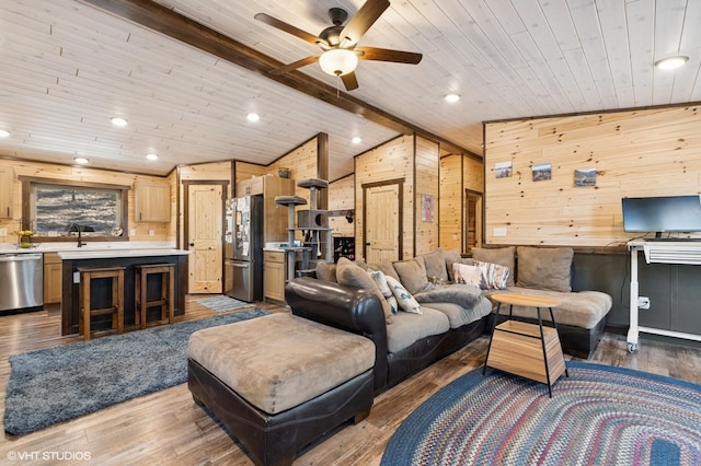 living area with wooden walls, ceiling fan, wood finished floors, vaulted ceiling with beams, and wood ceiling
