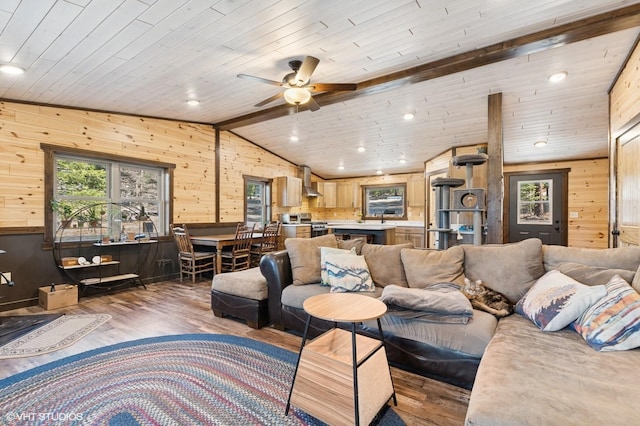 living room featuring lofted ceiling with beams, wood finished floors, and wooden walls