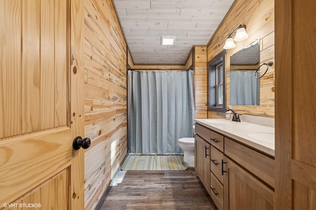 bathroom with toilet, wooden ceiling, a sink, wooden walls, and wood finished floors