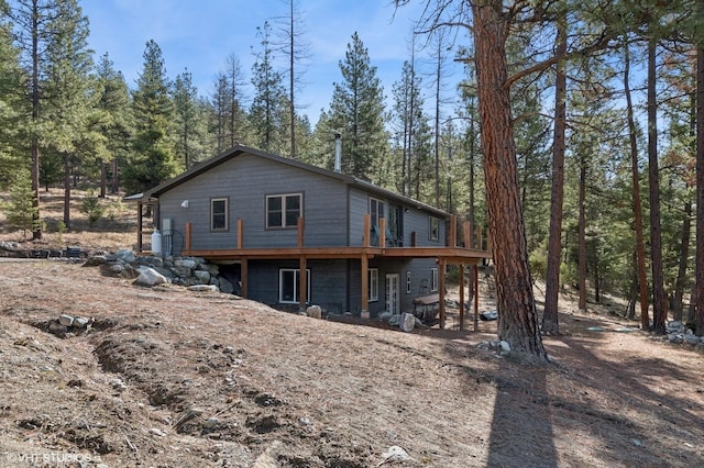 rear view of house featuring a wooden deck