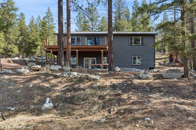 rear view of house with metal roof and a deck
