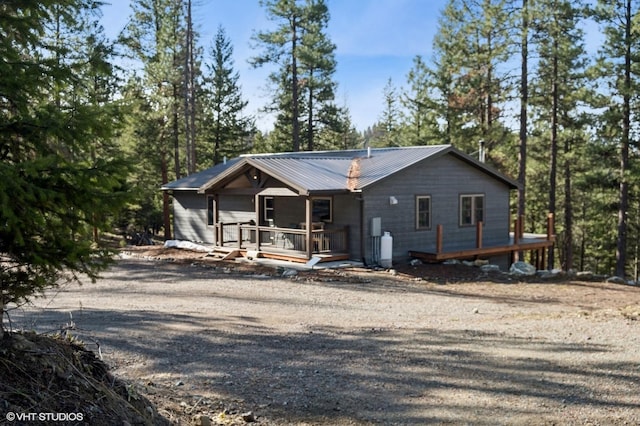 rustic home featuring a porch and metal roof