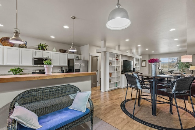 4239 W Babcock St Unit 7, Bozeman, MT 59718 - kitchen featuring light wood finished floors, wood counters, stainless steel appliances, white cabinetry, and hanging light fixtures
