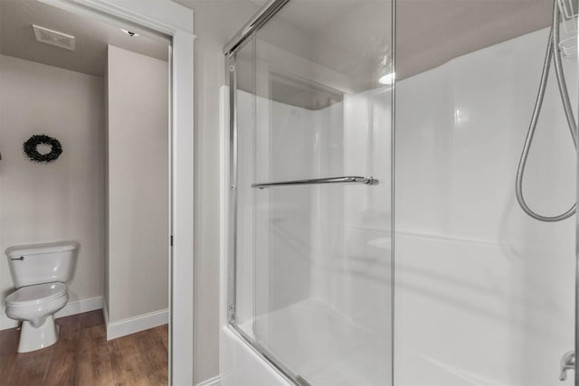 4239 W Babcock St Unit 7, Bozeman, MT 59718 - full bath with toilet, baseboards, visible vents, enclosed tub / shower combo, and wood finished floors