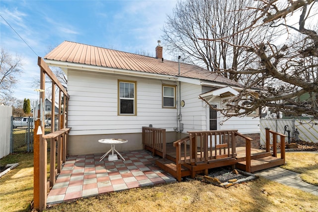744 2nd Ave W, Kalispell, MT 59901 - back of property with a metal roof, a chimney, a patio, and a deck