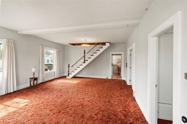744 2nd Ave W, Kalispell, MT 59901 - unfurnished living room featuring carpet flooring, a textured ceiling, stairway, and beamed ceiling