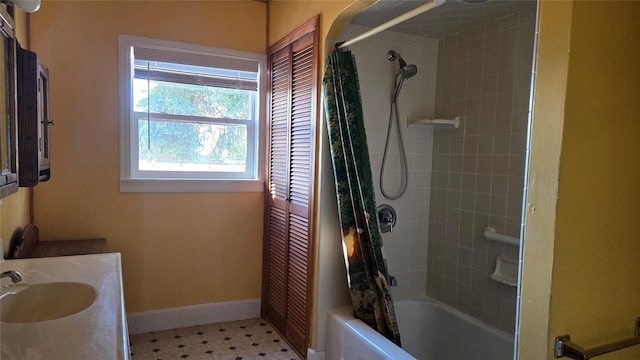 full bath with shower / bath combo, vanity, tile patterned floors, and baseboards