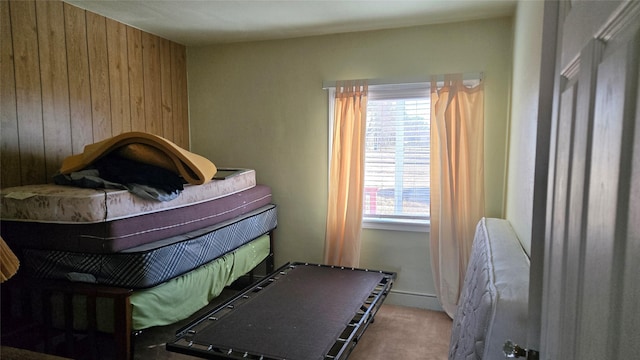 bedroom with wood walls and carpet flooring