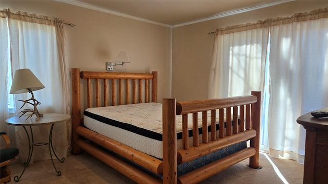 bedroom with ornamental molding and carpet flooring