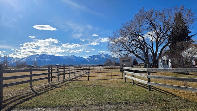 view of yard featuring fence, a rural view, and a mountain view