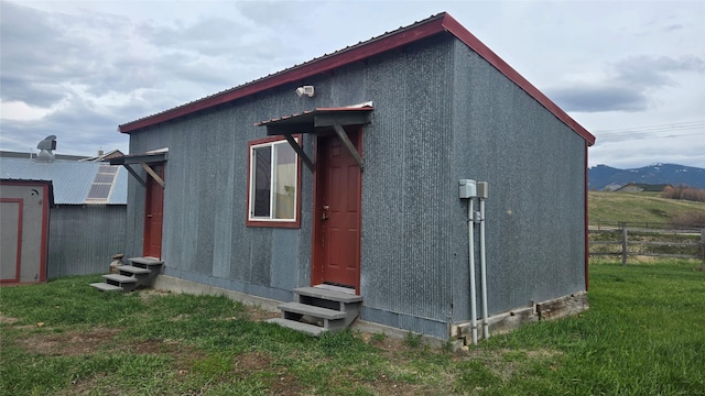 exterior space with metal roof, a yard, entry steps, and fence