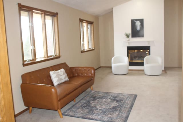 living area with a glass covered fireplace, plenty of natural light, and carpet floors