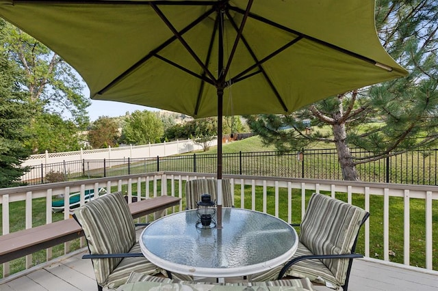 wooden deck featuring a yard, outdoor dining area, and a fenced backyard