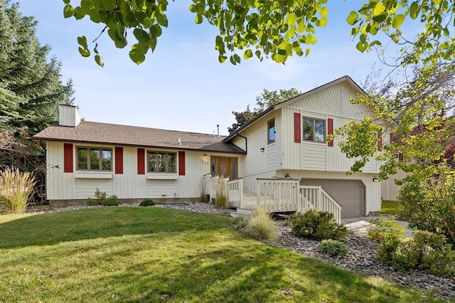 tri-level home featuring a front yard, an attached garage, a chimney, a shingled roof, and driveway