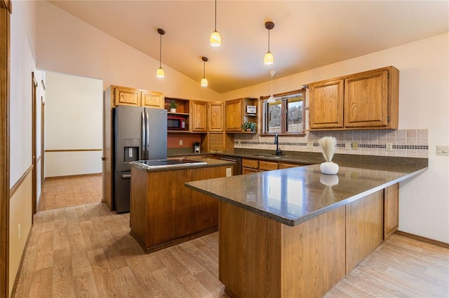 kitchen featuring a peninsula, open shelves, black appliances, a center island, and a sink