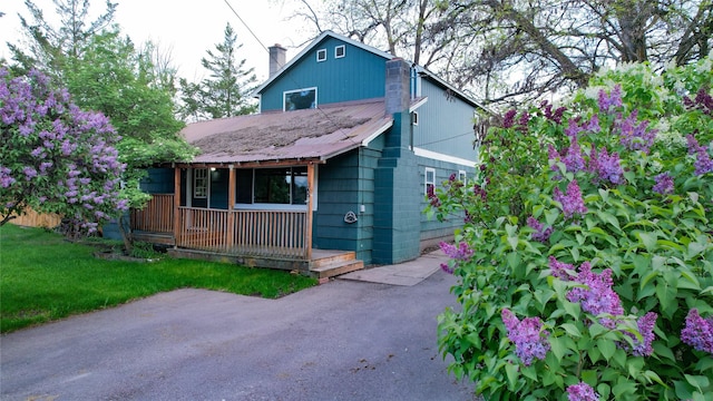 602 16th Ave E, Polson, MT 59860 - view of front of house featuring a chimney, a porch, and a front yard