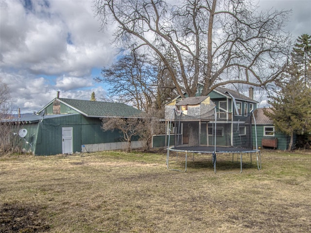 602 16th Ave E, Polson, MT 59860 - rear view of house featuring a trampoline, a lawn, a chimney, and a deck
