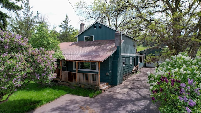 602 16th Ave E, Polson, MT 59860 - view of front of house featuring covered porch, a chimney, and a metal roof