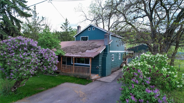 602 16th Ave E, Polson, MT 59860 - chalet / cabin featuring a porch, a chimney, and metal roof