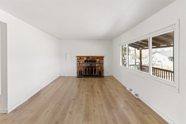 602 16th Ave E, Polson, MT 59860 - unfurnished living room with light wood finished floors, a fireplace, and baseboards