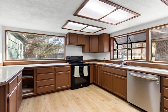 602 16th Ave E, Polson, MT 59860 - kitchen with black electric range oven, stainless steel dishwasher, a sink, light wood-style floors, and plenty of natural light