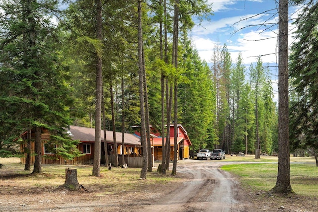 view of front of house featuring driveway and a wooded view