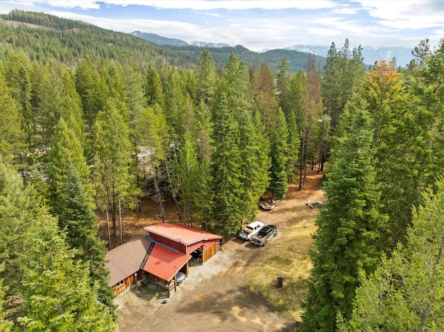 aerial view featuring a wooded view and a mountain view