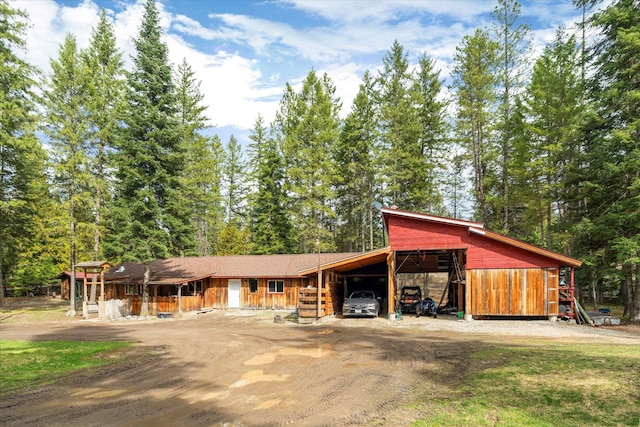 view of front of home featuring a carport and dirt driveway