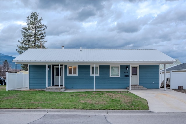 308 Dakota Ave, Libby, MT 59923 - ranch-style house featuring covered porch, a front lawn, fence, and metal roof