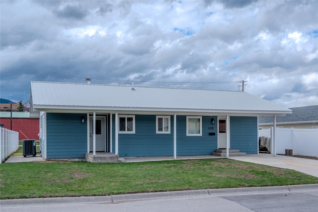308 Dakota Ave, Libby, MT 59923 - ranch-style home with metal roof, fence, a front lawn, cooling unit, and a porch