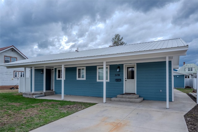 308 Dakota Ave, Libby, MT 59923 - view of front facade featuring a porch, fence, and metal roof